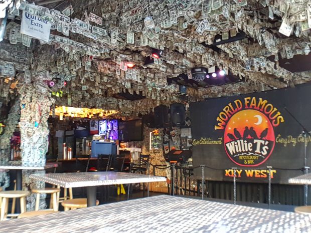 Bar com várias notas de dólares no teto.